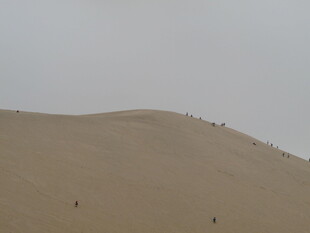 沙漠上人在沙丘上行走