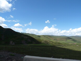 蓝天白云下的翠绿山峦