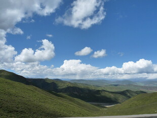 蓝天白云下的翠绿山峦