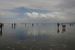 海边漫步的人群与美丽倒影