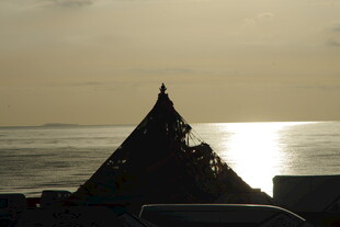 夕阳下的尖顶建筑与海面