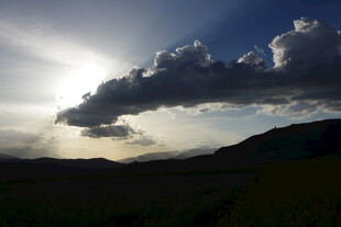 夕阳下的山峦与乌云