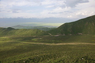 广袤绿野间的山峦风光