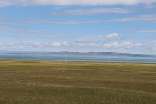 辽阔草原与远方蔚蓝湖泊