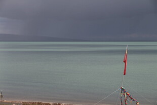 海边阴沉天色下的红色旗帜