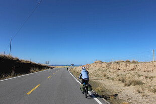 骑行者驰骋于空旷公路