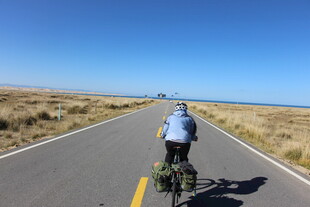 一人骑行于开阔公路之上