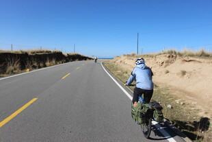 骑行者在旷野公路上独行