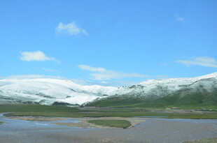 雪山下的开阔河畔风光