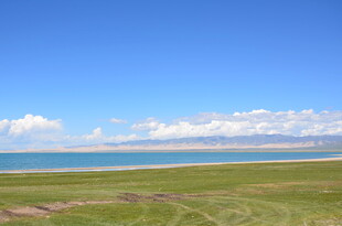 草原蓝天与远处水域美景