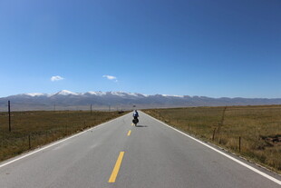 公路骑行者 远方雪山蓝天