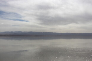 广阔盐湖与多云天空景象