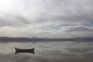 孤舟静泊于平静湖面