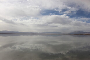 平静湖面映蓝天白云