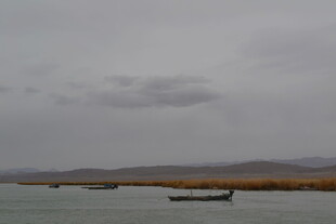 阴天湖面小船与远山景色