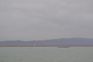 阴天的平静湖面与远山