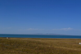 广阔草原与远方蓝色海洋