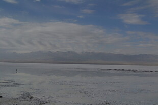 广阔盐湖与远处山峦景色