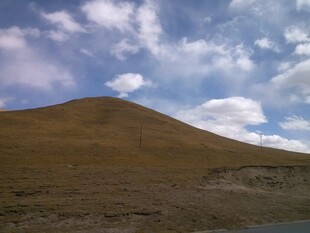 蓝天白云下的山丘景观