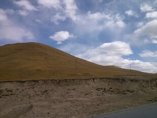 公路旁的山丘与蓝天白云