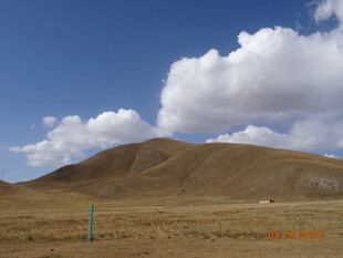 广袤旷野中的山丘与白云