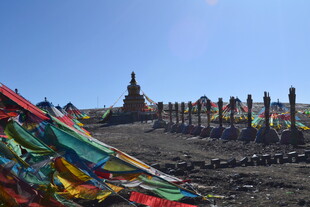 高原经幡与远处佛塔景观