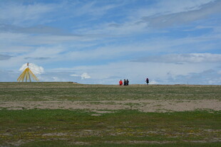 草原上的行人与远处建筑