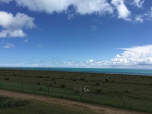 草原蓝天与远处的海