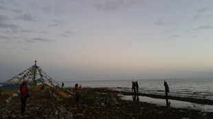 海边黄昏时的木架与行人