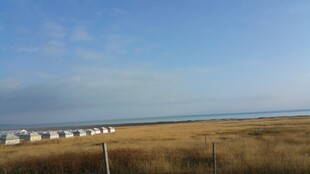 草原上的房屋与远方大海