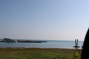 海边草地与远处船只景观