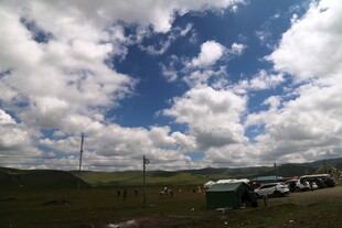 草原上的车辆与蓝天白云