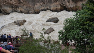 湍急河流旁的观景人群