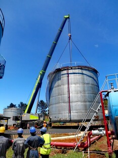 工人操作起重机安装储水罐