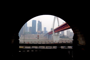 透过圆洞看城市桥梁风景