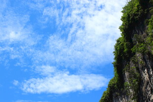 蓝天白云下的陡峭山壁