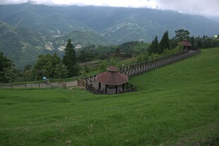 山间绿草地中的小屋