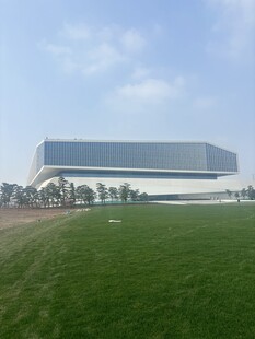 现代建筑矗立绿色田野间