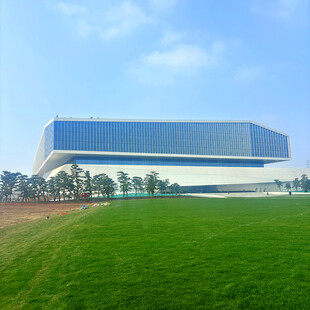 现代建筑矗立绿色草地旁