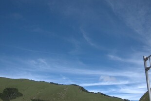 蓝天青山间的电线杆