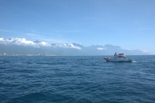 海上孤舟与远处雪山美景