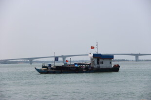 海上渔船与远处桥梁景观