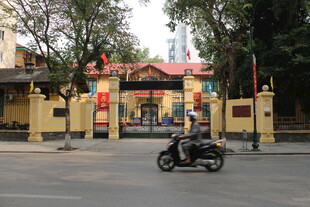 越南骑摩托经过的黄色建筑大门