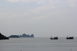 越南海上船只与远处岛屿景观