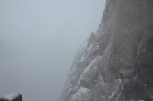 雾中覆雪的陡峭山壁