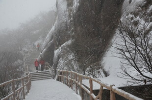 雪中山间栈道上的行人