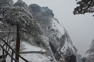 雪覆山峦的险峻栈道景观