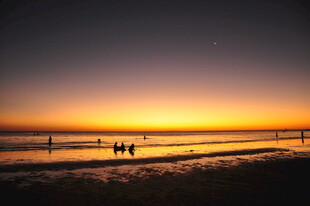 夕阳下的海边漫步身影