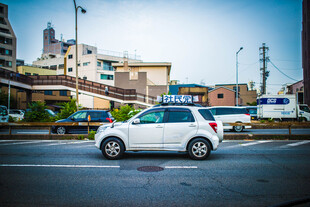 日本城市街道上的白色家用轿车