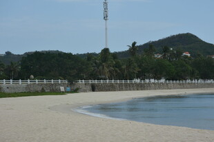 三亚宁静海滩与远处山峦美景